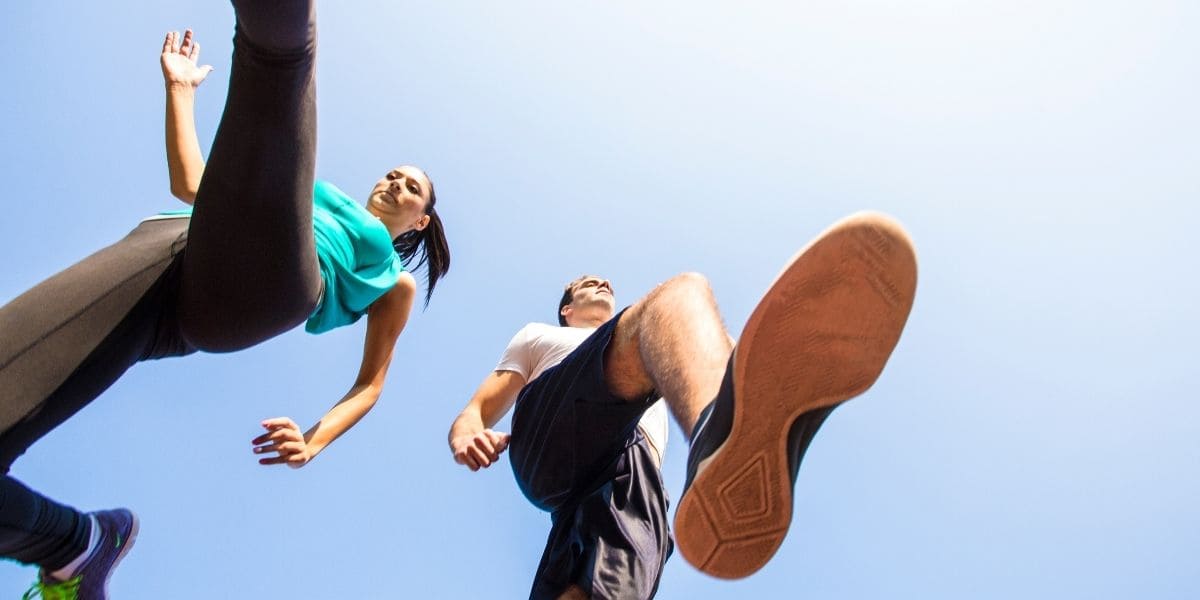 Two runners training outdoors on a sunny day